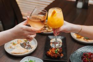 two people are holding up glasses of wine at Cabarfeidh Hotel in Stornoway