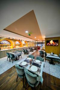 a restaurant with tables and chairs and a fireplace at İstport Hotels in Arnavutköy