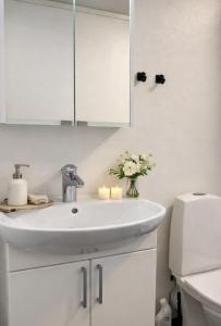 a white bathroom with a sink and a mirror at Frost Longstay City in Kiruna