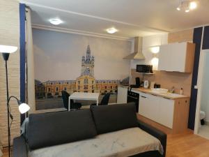 a living room with a couch and a kitchen with a building at Le Coeur du Beffroi in Douai