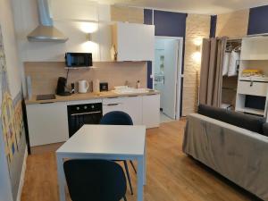 a kitchen and living room with a table and chairs at Le Coeur du Beffroi in Douai
