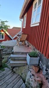 a wooden bench sitting outside of a red building at Lilla huset in Klädesholmen +3 photos