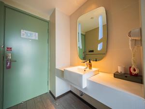 a bathroom with a sink and a mirror at Ibis Chengdu High-tech Electronics University in Pi +64 photos
