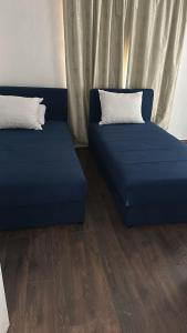 two beds with blue sheets in a room at APARTMANI Sarajevo in SJJ +3 photos