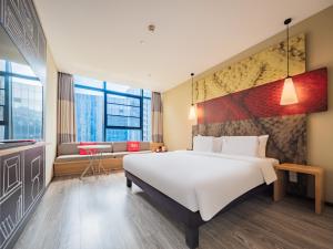 a bedroom with a large white bed and a couch at Ibis Chengdu High-tech Electronics University in Pi