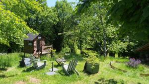 a garden with a table and chairs and a bird house at Les 3 pruniers in Cieux