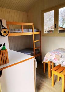 a small room with a bunk bed and a table at Camping Le Vert-Bois - Corrèze in Saint-Martin-la-Méanne