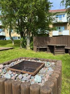 a fire pit with rocks and a bench in a yard at Frost Longstay City in Kiruna