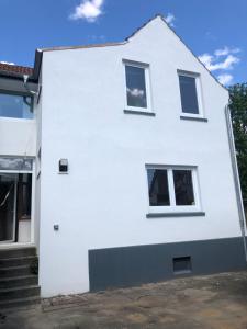 a white house with three windows and stairs at Nord & Feld Kajüte in Bremerhaven