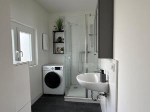 a bathroom with a sink and a washing machine at Nord & Feld Kajüte in Bremerhaven