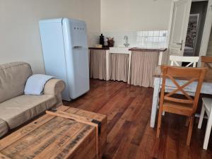 a living room with a couch and a refrigerator at Domaine Pyrénées Passions - Gîtes de Charmes & Caractère in Estadens