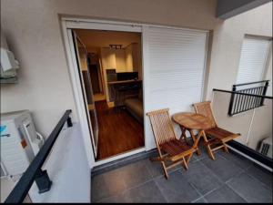 a balcony with a table and chairs and a living room at Master Quart studio apartment in Podgorica +4 photos