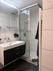 a bathroom with a sink and a glass shower at Bergquelle 2. OG in Bettmeralp +42 photos
