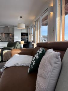 a living room with a brown couch with pillows at Bergquelle 2. OG in Bettmeralp