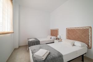 two beds in a room with white walls at Les Villetes in Moncófar