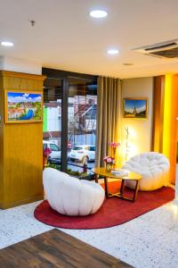 a living room with two white chairs and a table at İstport Hotels in Arnavutköy