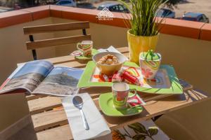 a table with two plates of food and a book at Casa Torre di Nora - Morada in Pula