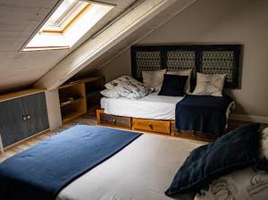 a attic bedroom with two beds and a window at Casa de Tintas in Cuenca