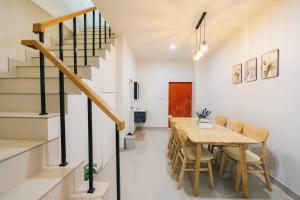 a dining room with a wooden table and chairs at 11 House - 9 mins drive to LeeGarden,parking available in Ban Kohong