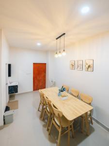 a dining room with a wooden table and chairs at 11 House - 9 mins drive to LeeGarden,parking available in Ban Kohong
