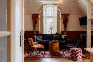 a living room with a blue couch and chairs at Herberg d'n brouwer in Zeeland