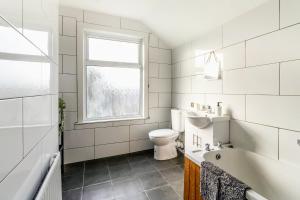 a bathroom with a toilet and a sink and a window at Barnwell by Holmesdale Homes in Kettering