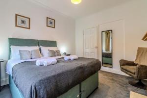 a bedroom with a bed with two towels on it at Barnwell by Holmesdale Homes in Kettering +16 photos