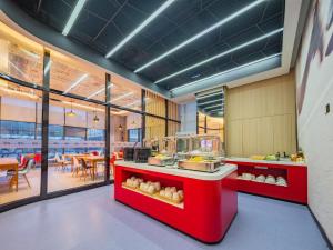 a restaurant with a red counter with food on it at Ibis Chengdu High-tech Electronics University in Pi