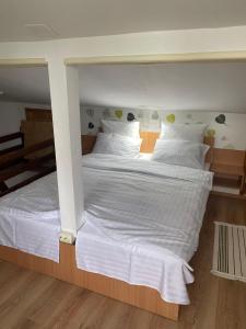 a large white bed with white sheets and pillows at Chalet Traian & Ruxandra in Sinaia