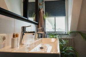 a bathroom with a sink and a mirror at Herberg d'n brouwer in Zeeland +17 photos
