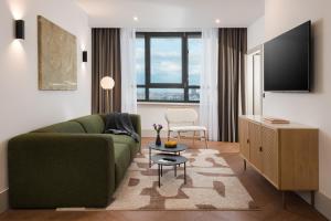 a living room with a green couch and a tv at master Wola in Warsaw
