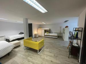 a room with two beds and a yellow chair in it at Villa Bosque Albite in Llanera +39 photos