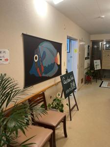 a sign in a hallway with a picture of a fish on the wall at ゲストハウス假穂 in Yoron