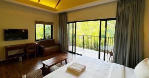 a living room with a table and a large window at Flower Valley Plantation Homestay in Munnar