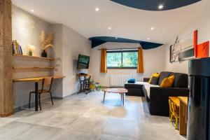 a living room with a couch and a table at Les Bobos à la ferme in La Madelaine-sous-Montreuil