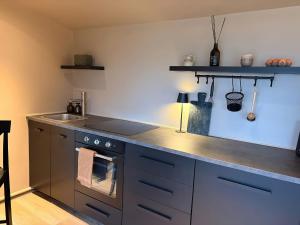 a kitchen with a stove top oven next to a sink at Heath Hideaway in Sowerby Bridge