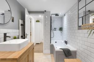 a bathroom with a white tub and a sink at Beautiful Apartment with Parking Central Exeter in Dean