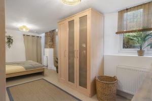 a bedroom with a bed and a wooden cabinet at Beautiful Apartment with Parking Central Exeter in Dean +14 photos