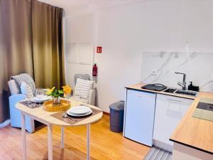 a kitchen with a table and a small kitchen with a sink at Bela Vista Studio in Ponta Delgada +16 photos