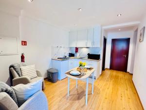a kitchen and a living room with a table at Bela Vista Studio in Ponta Delgada