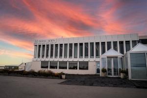 a white building with a sign on top of it at Hotel Höfn in Höfn +58 photos