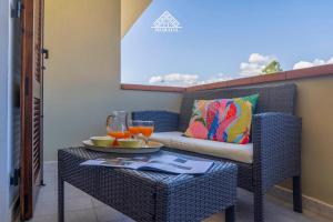 a balcony with a couch and a table with drinks on it at Casa Torre di Nora - Morada in Pula