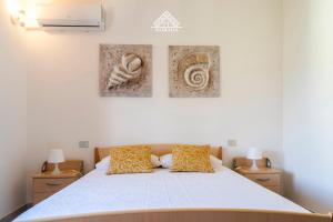 a bedroom with a bed with two pictures on the wall at Casa Torre di Nora - Morada in Pula
