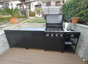 a black barbecue grill with a sink in a backyard at Villa Buby in Pettenasco
