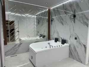 a white bathroom with a sink and a shower at Firepalace Gabala in Gabala +39 photos