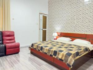 a bedroom with a bed and a red chair at Residence MiMi Alouar Ziguinchor in Tilel