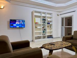 a living room with two chairs and a table and a tv at Residence MiMi Alouar Ziguinchor in Tilel
