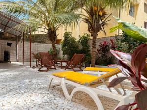 a patio with a table and chairs and palm trees at Residence MiMi Alouar Ziguinchor in Tilel