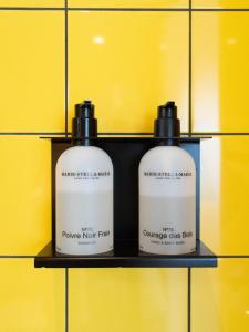 two bottles on a shelf in front of a yellow wall at De Bossche Kraan in Den Bosch +12 photos