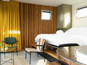 a bedroom with a bed and a table and chairs at De Bossche Kraan in Den Bosch